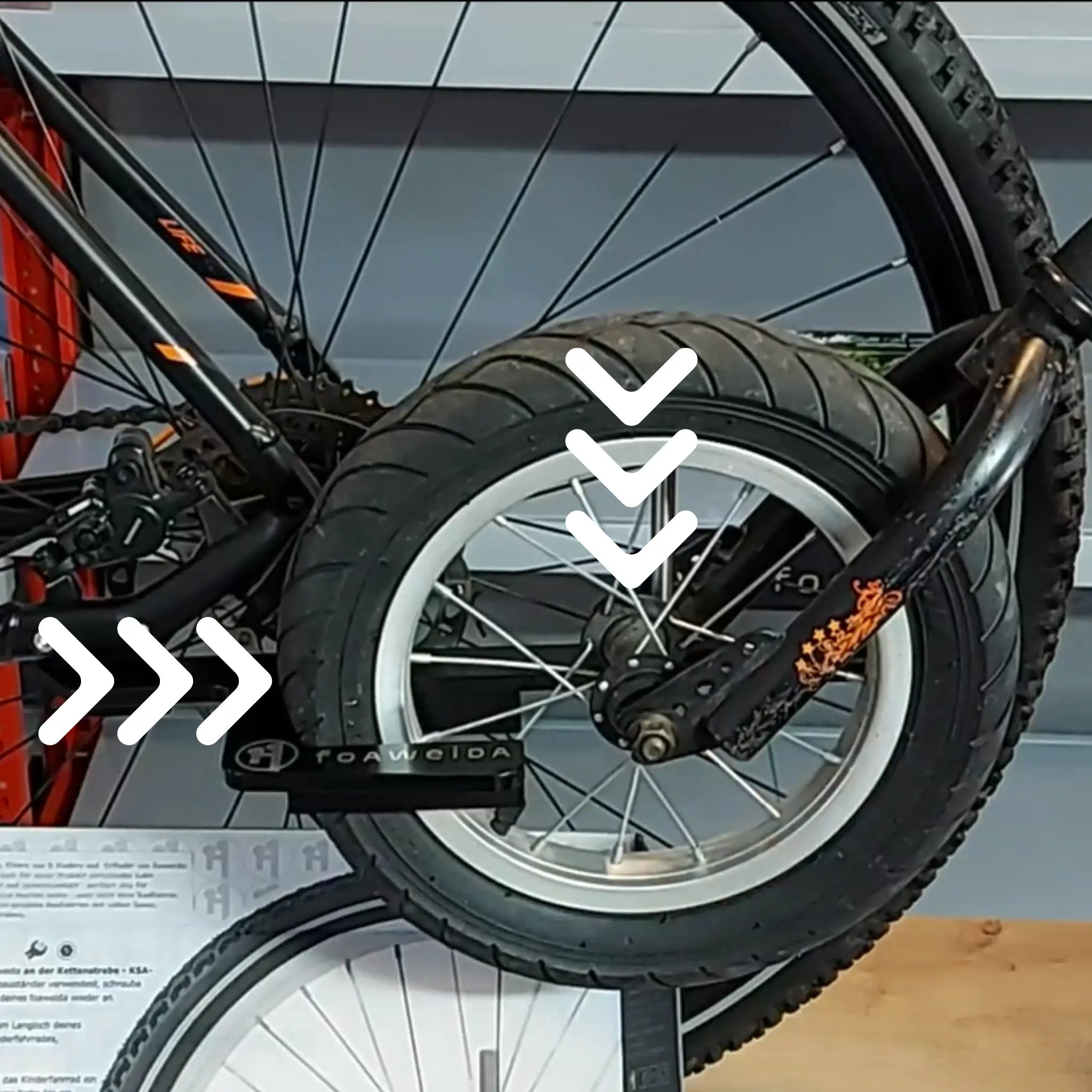 Montage Schritt 3: Kinderfahrrad einklicken, Festlegung ist stabil wenn Radnabe aufliegt und Vorderreifen leicht deformiert ist.